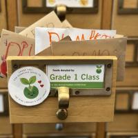 Photograph of a drawer of the Seed Library showing a label saying "Seeds donated by Grade 1 Class"